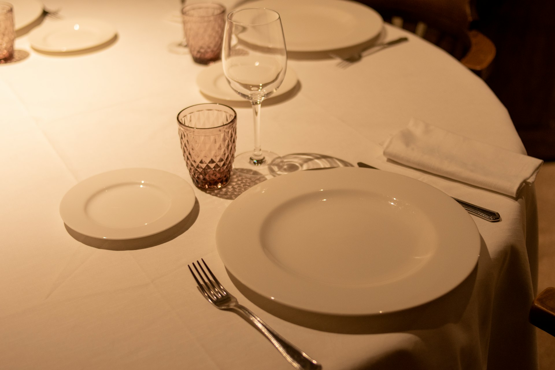 a table with a white table cloth and place settings